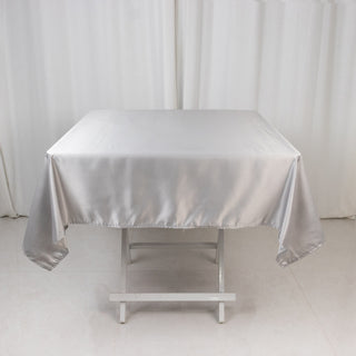 Silver satin tablecloth draped over a white table