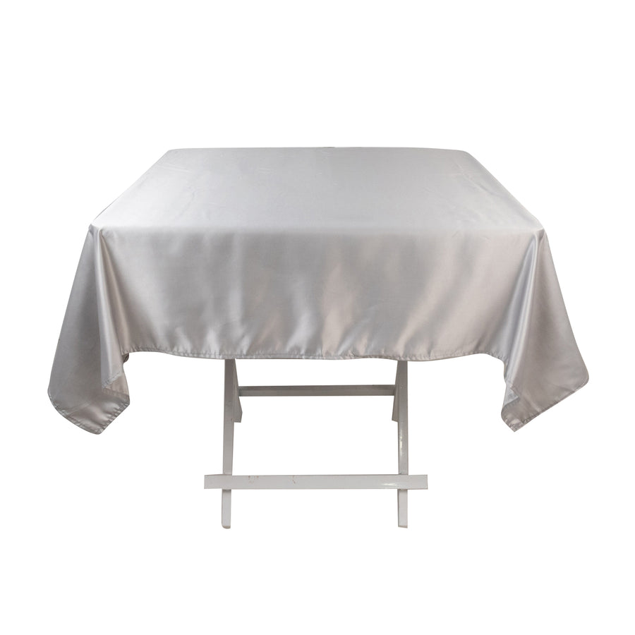 Silver satin tablecloth draped over a white folding table