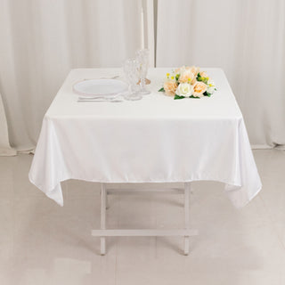 Elegant white table setting with flowers and glassware.