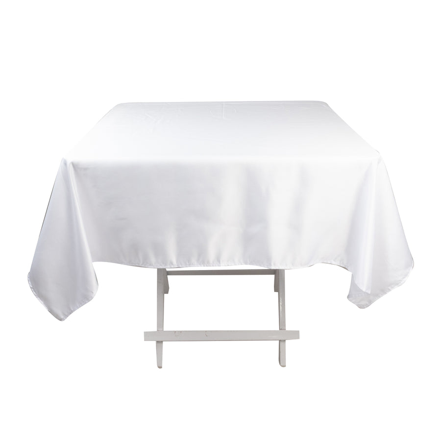White tablecloth draping over a table on a plain backdrop