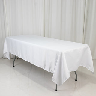 White tablecloth draped over a folding table in a studio setting.