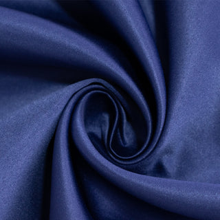 Navy blue satin fabric swirl texture close-up.