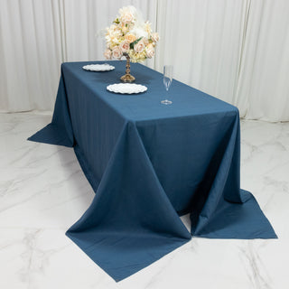 Elegant blue tablecloth draped on a table with floral centerpiece and dinnerware.