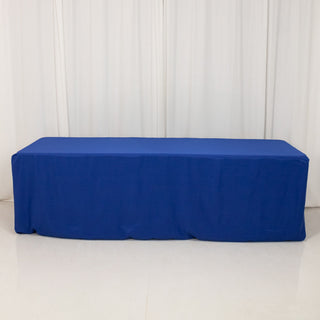 Blue tablecloth draped over a table on a plain backdrop.