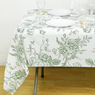Floral patterned tablecloth on a dining table with plates and glassware.