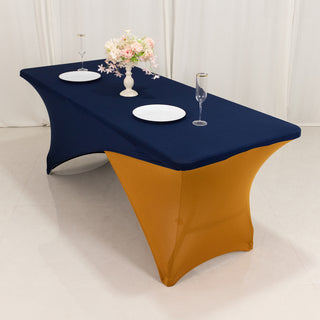Navy and gold tablecloth draped over a rectangular table set with plates and glasses.