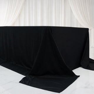 Black table covered with fabric in a minimalist setting.