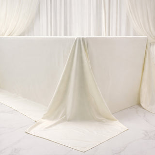 Elegant cream tablecloth draped over a table in a soft, neutral setting.