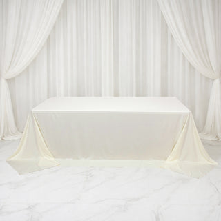 White tablecloth draped over a table with elegant curtains in the background.