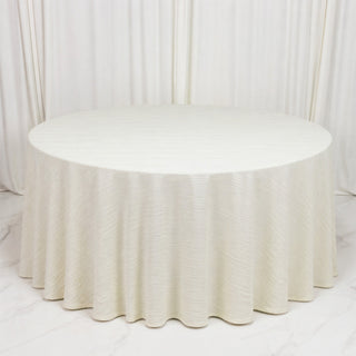 Elegant round ivory table with pleated linen drape on a white backdrop