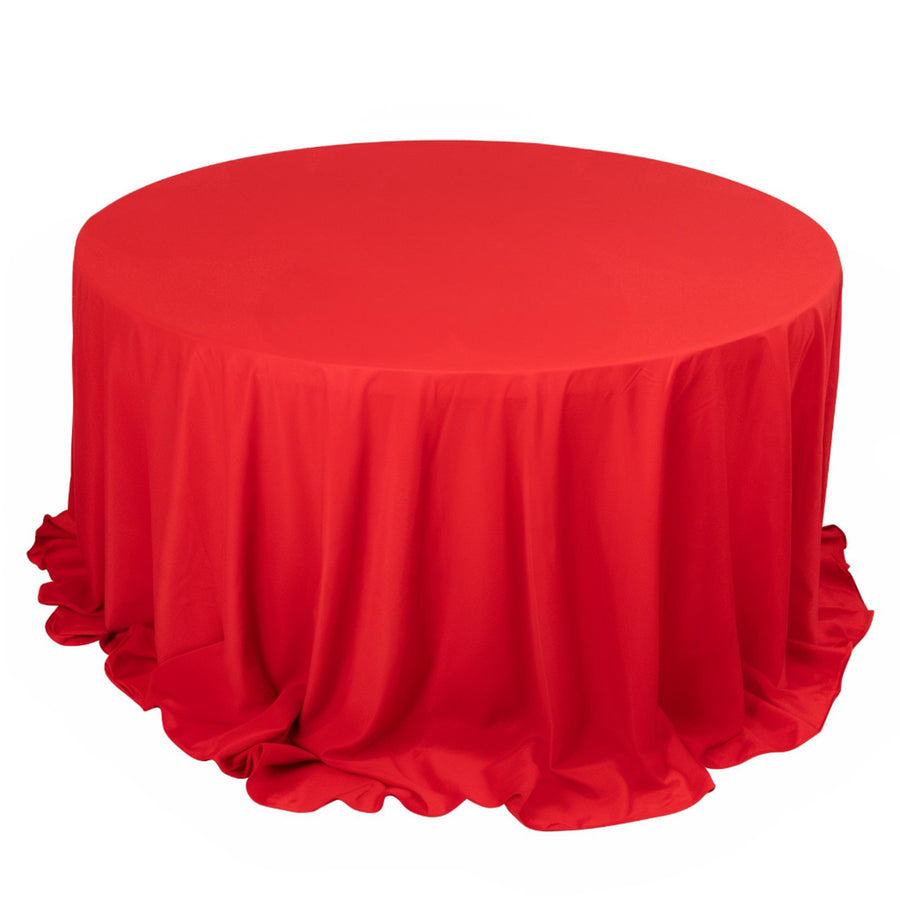 Red round tablecloth with elegant draping on a plain white background
