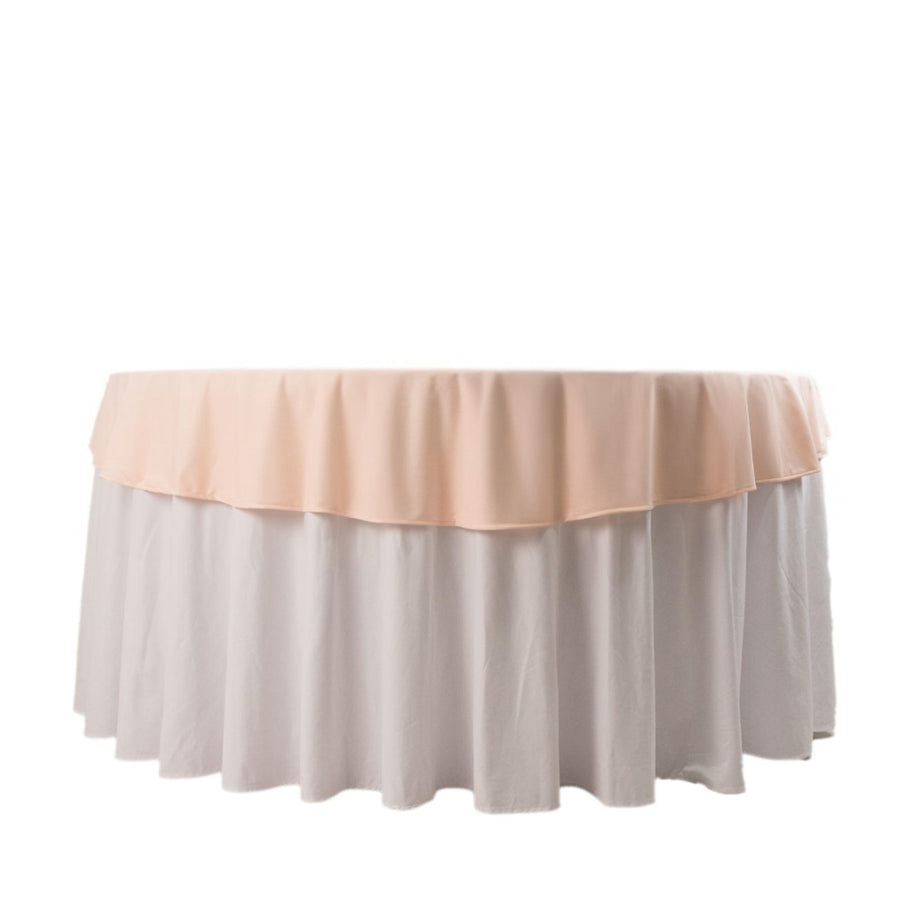 Round table with a layered pink and white tablecloth