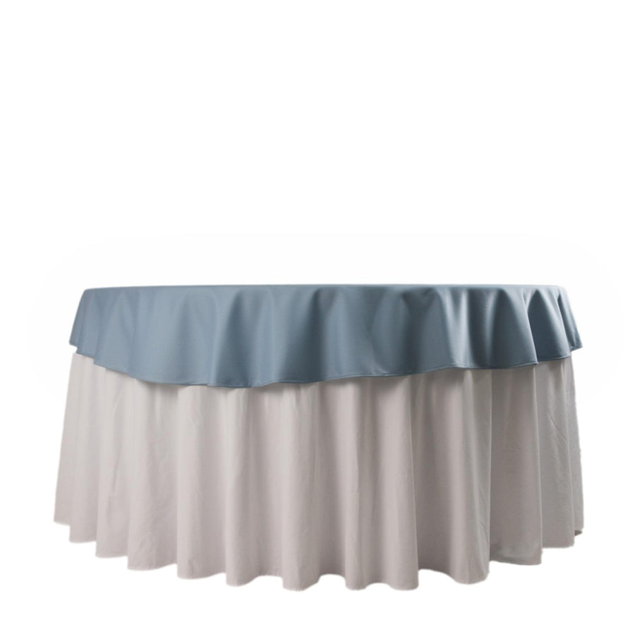 Round table with blue and white tablecloth, studio shot.