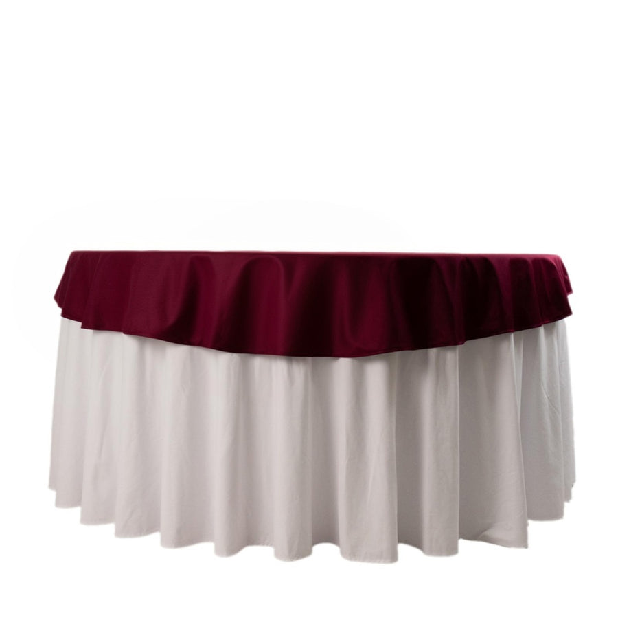 Burgundy and white tablecloth draped over a round table