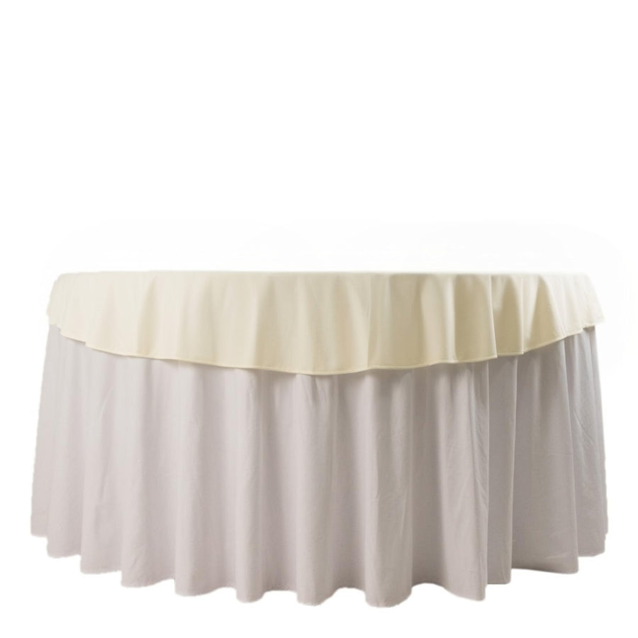 Round table with cream and white tablecloth draped elegantly.