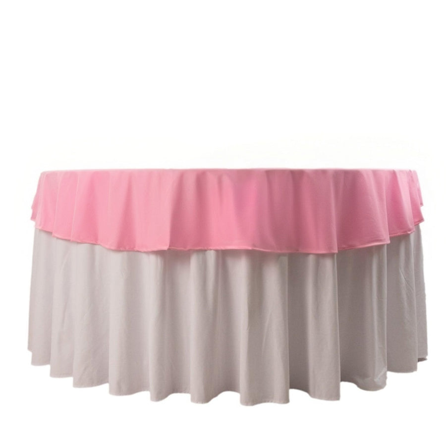Pink and white tablecloth with ruffles on a round table