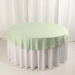 Round table with a light green tablecloth and white overlay
