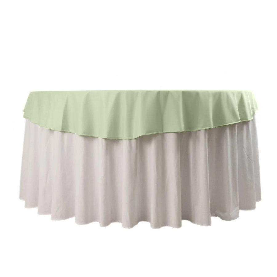 Green and white tablecloth with ruffled edges on a round table