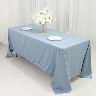 Elegant blue tablecloth draped over a table with floral centerpiece and plates.