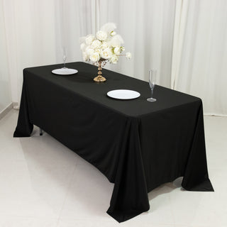 Elegant black tablecloth draped over a dining table with floral centerpiece.