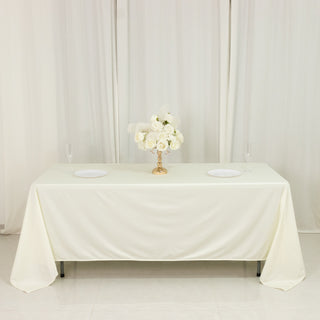 Elegant table setting with flowers and plates on a white tablecloth.