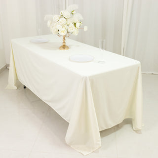 Elegant ivory tablecloth draped over a table with floral centerpiece and dining plates.