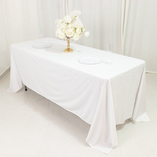 Elegant white table set with flowers and plates for a sophisticated dining experience.