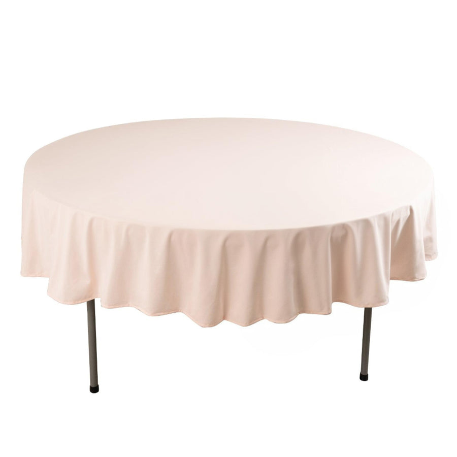 Round table with a soft pink tablecloth draped elegantly.