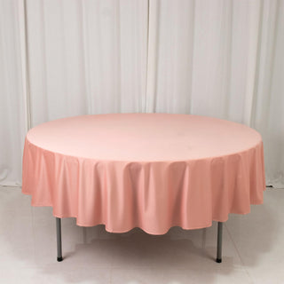 Round pink tablecloth draped over a table in a studio setting.
