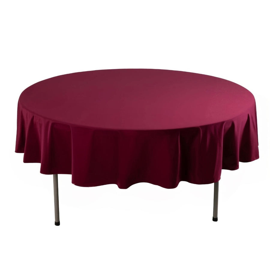 Round burgundy tablecloth draped over a circular table