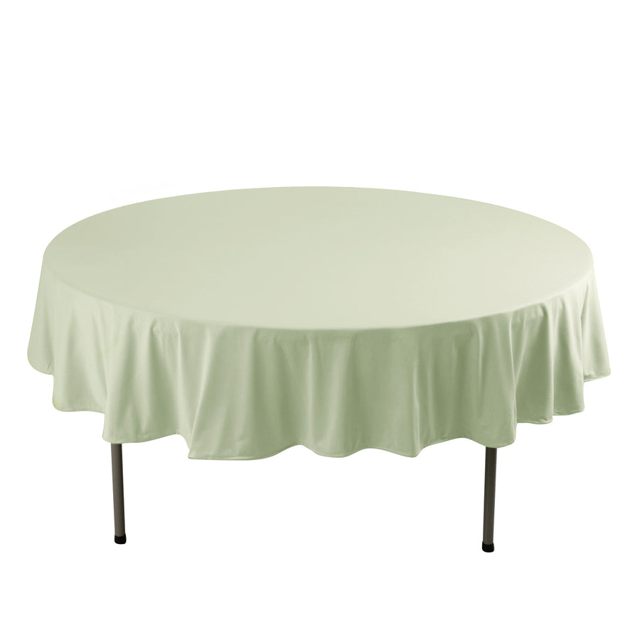 Round table covered with a light green tablecloth.