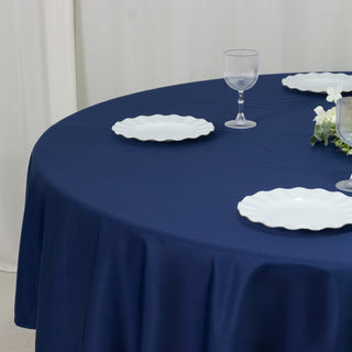 Navy tablecloth with white plates on a round table setting