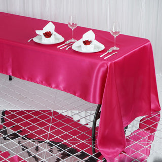 Elegant pink satin tablecloth with dining setup and decorative napkins.