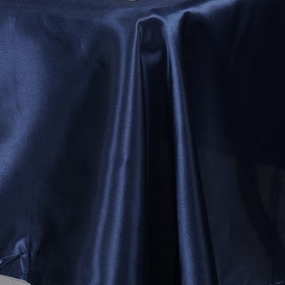 Navy satin fabric draped elegantly on a surface.