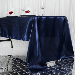 Navy satin tablecloth elegantly draped on a table with decorative elements.