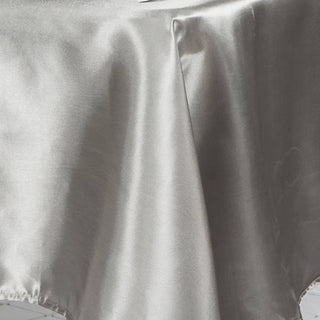 Silver satin tablecloth draping elegantly on a surface.