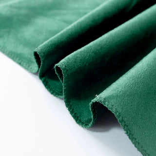 Green suede fabric close-up with folded edges and soft texture