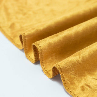 Golden velvet fabric folds close-up texture detail