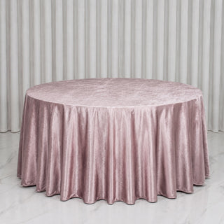 Round blush pink velvet tablecloth on a banquet table with white drapes