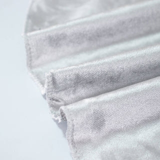 White pleated fabric close-up with soft texture and frayed edges