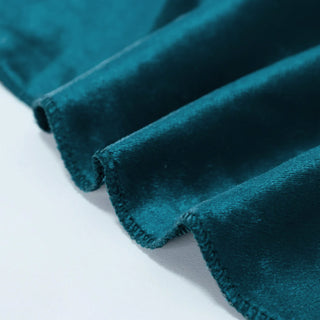 Teal velvet fabric close-up with soft textured folds