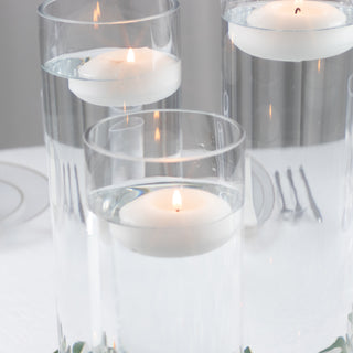 Floating candles in glass cylinders with water, creating an elegant ambiance.
