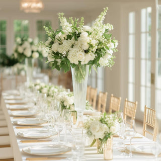 Elegant white floral arrangement on a beautifully set dining table.