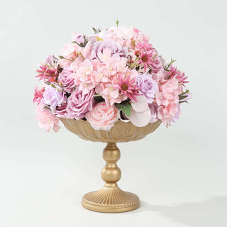 Pink floral arrangement in a gold pedestal vase.