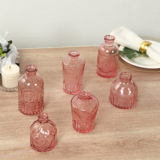 Set of vintage pink glass bottles on a wooden surface.