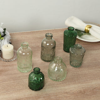 Set of vintage-style glass vases in various shapes and sizes on a wooden table.