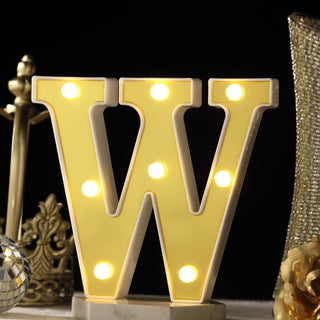 Illuminated yellow letter "W" marquee light on a decorative table.