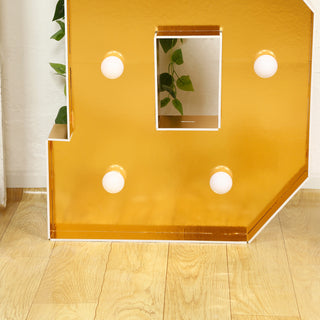 Gold marquee letter with light bulbs and a cutout design.