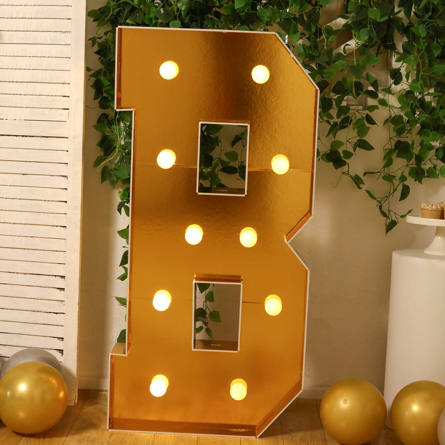 Gold marquee letter B with lights, perfect for events or decorations.