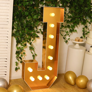 Gold marquee letter J with lights, perfect for events and decorations.